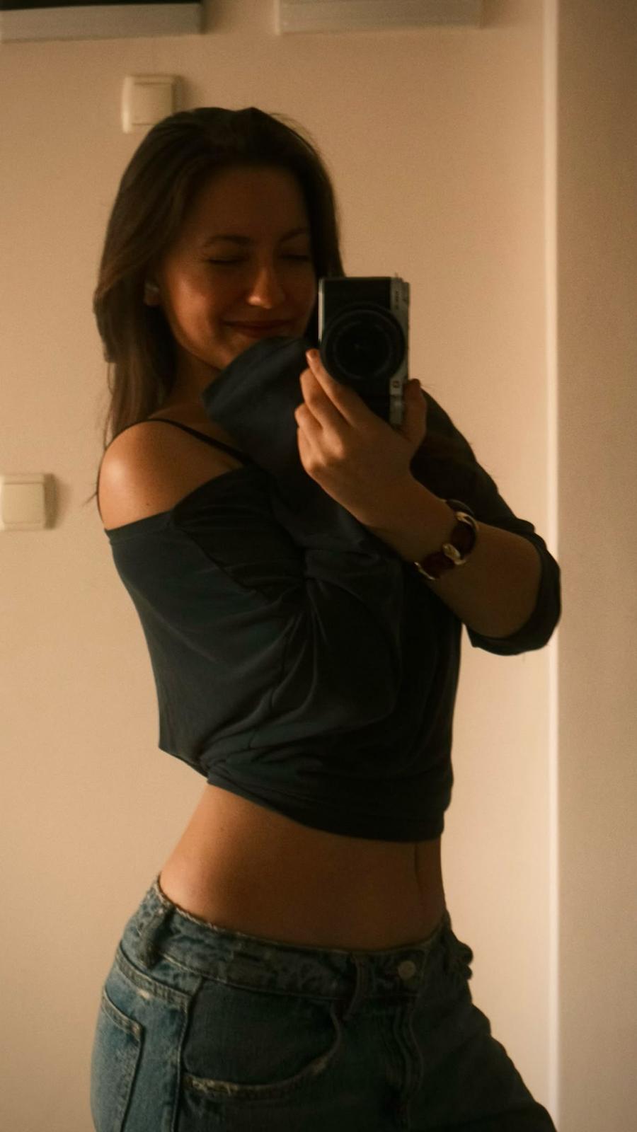 Yaren smiling in a mirror, holding her camera